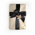 1 lb fancy wrapped box. Gold, and white pin-stripped wrapping paper. Tied with a black satin ribbon and white decorative piece